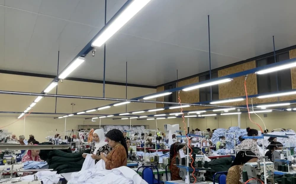 Rows of sewing machines and operators on the Context production floor.