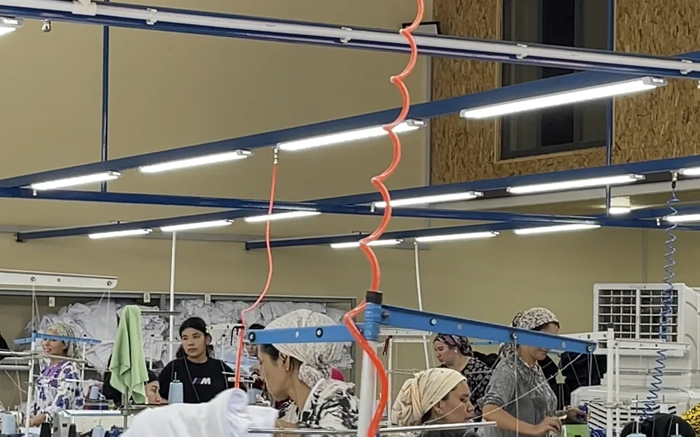 Operators sewing custom garments on the production line.